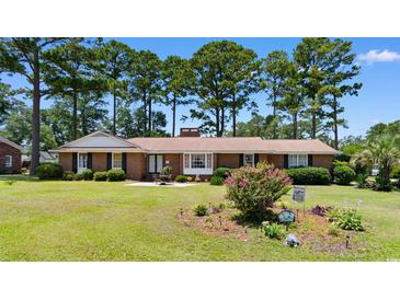 Charming single-story brick home with well-manicured front yard and mature trees at 207 Green Lake Dr., Myrtle Beach, SC 29572