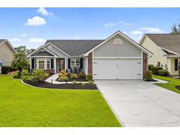 Charming single-story home with manicured lawn, lush landscaping, and a two-car garage at 2783 Sanctuary Blvd., Conway, SC 29526