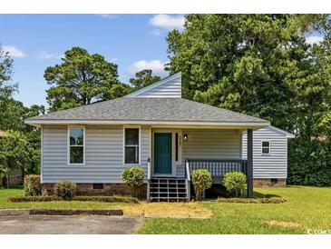 Charming single-story home featuring a teal front door, mature trees, and a well-maintained lawn at 3537 Lighthouse Way, Myrtle Beach, SC 29577