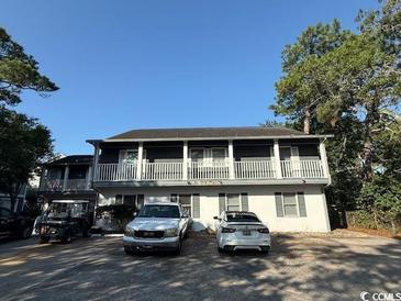Two-story home with a gray exterior, white trim, and parking at 403 71St Ave. N # 14, Myrtle Beach, SC 29575