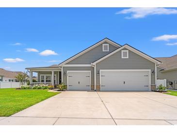 Charming single-Gathering home with a two-car garage, manicured lawn, and inviting front porch on a sunny day at 892 Harrison St., Myrtle Beach, SC 29579