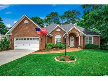 Charming brick home with an arched entry, brick walkway, beautiful lawn and two car garage at 911 Tilghman Forest Dr., North Myrtle Beach, SC 29582