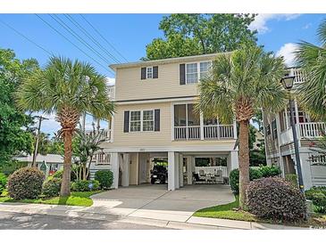 Inviting two-story home with well-maintained landscaping, palm trees, and convenient ground-level parking at 1011 Sable Palm Way, Surfside Beach, SC 29575