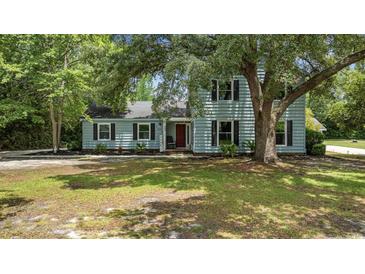 Charming two-story home featuring a red door and well-maintained landscaping in a serene, wooded setting at 109 Wofford Rd., Conway, SC 29526