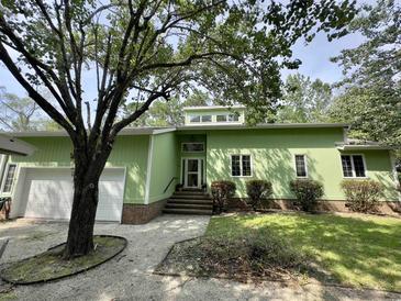 Charming single-story home boasts a light-green exterior with brick accents and a well-maintained front yard at 116 Capt Anthony White Ln., Georgetown, SC 29440