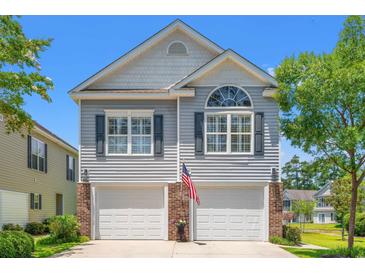 Charming two-story home featuring a double garage, and an inviting front yard at 1415 Powhaton Dr., Myrtle Beach, SC 29577