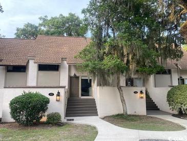 Charming townhome featuring a classic design and inviting front entrance with mature landscaping at 18 Canvas Back Cove # 122, Georgetown, SC 29440