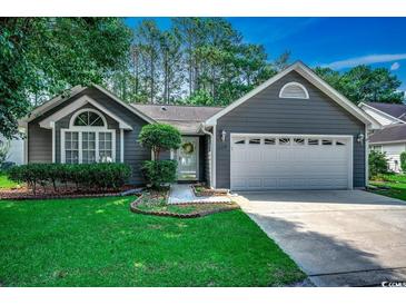 Charming single-story home with a two-car garage and beautiful landscaped front yard at 220 Gateway Dr., Little River, SC 29566