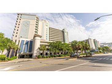 Multi-story condo building with light blue accents, surrounded by lush landscaping and palm trees at 2401 S Ocean Blvd. # 1262, Myrtle Beach, SC 29577
