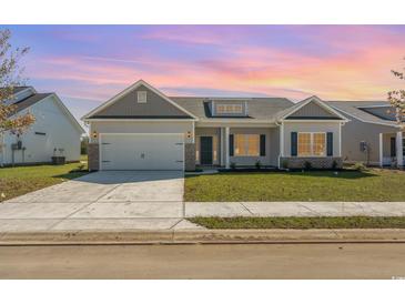 Charming single-story home featuring a two-car garage, well-manicured lawn and beautiful front yard landscaping at 3231 Little Bay Dr., Conway, SC 29526