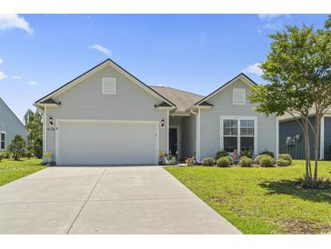 Charming one-story home with a well-maintained lawn, two-car garage, and a lovely landscaped front yard at 4136 Alvina Way, Myrtle Beach, SC 29579