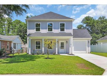 Charming two-story home with a manicured lawn, covered porch, and attached garage at 4329 Landing Rd., Little River, SC 29566