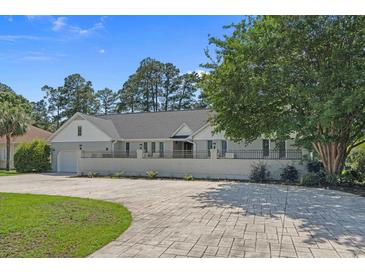 Charming one-story home with an expansive driveway, manicured lawn, and mature trees at 4709 National Dr., Myrtle Beach, SC 29579