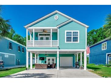 Charming raised beach home with a blue exterior, covered parking and second story balcony at 1733 24Th Ave. N, North Myrtle Beach, SC 29582
