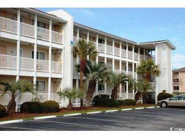 Charming condo complex with multiple floors, balconies, parking, and lush landscaping at 1919 Spring St. # B12, North Myrtle Beach, SC 29582