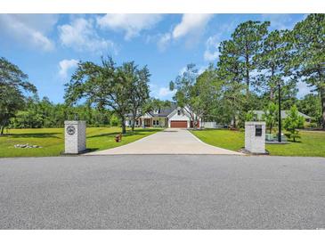 Beautiful two-story home with a long drive, lush lawn, and mature trees at 2192 Eastwoods Dr., Conway, SC 29526