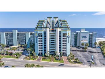 Stunning exterior shot of an ocean-front resort with blue facade, balconies, and immaculate landscaping at 6804 North Ocean Blvd. # 515, Myrtle Beach, SC 29572