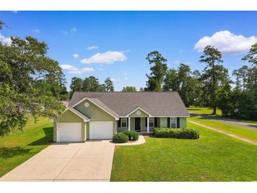 Charming single-story home features a well-manicured lawn, two-car garage, and inviting front entrance at 943 Oak St., Aynor, SC 29511