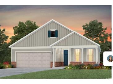 Charming single-story home featuring a welcoming front porch, two-car garage, and well-manicured lawn at 1009 Lady Bird Way, North Myrtle Beach, SC 29582