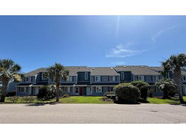 View of the exterior of the condo building with lush green landscaping at 1851 Colony Dr. # 5M, Surfside Beach, SC 29575