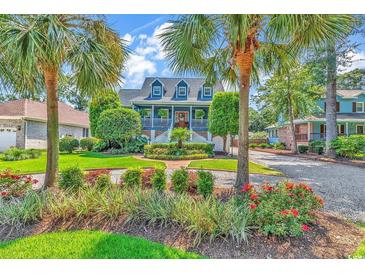 Charming two-story home with a manicured front yard, lush landscaping, and beautiful curb appeal framed by palm trees at 315 14Th Ave. N, Surfside Beach, SC 29575