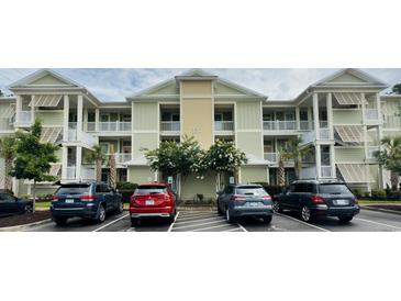 Inviting condo building with neutral paint, white trim, ample parking, and balconies on each floor at 130 Puffin Dr. # 2B, Pawleys Island, SC 29585