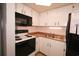 Efficient kitchen featuring white cabinets, black appliances, and warm countertop at 1501 S Ocean Blvd. # 1048, Myrtle Beach, SC 29577