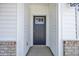 Close-up of the front door with a grey finish and side-brick accents at 546 Beckham Ct., Murrells Inlet, SC 29576