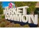 Monument sign for The Market Common with a hibiscus flower and white block lettering at 780 Maxine Ct. # 8E, Myrtle Beach, SC 29577