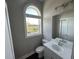 Small bathroom with white vanity and arched window at 1316 Marina Bay Dr., North Myrtle Beach, SC 29582