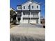 Three-story home with gray siding, white trim, and a three-car garage at 1316 Marina Bay Dr., North Myrtle Beach, SC 29582