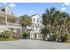 Side view of the new construction home with palm trees, a balcony, and white siding at 410 5Th Ave. S, North Myrtle Beach, SC 29582