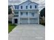 Exterior of a three-story white house with balconies and a three car garage at 410 5Th Ave. S, North Myrtle Beach, SC 29582
