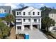 Front exterior of a new construction home with a three-car garage and a balcony at 410 5Th Ave. S, North Myrtle Beach, SC 29582