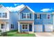 Two-story light blue home with white garage door and landscaping at 718 Nw Palm Frond Way # 66, Calabash, NC 28467