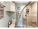 Tiled shower includes a bench, shelf, and a glass door; the room features a toilet and storage cabinet at 4396 Baldwin Ave. # 47, Little River, SC 29566