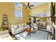 Open-concept living room with high ceilings, large windows, and comfortable seating flows into the adjacent kitchen area at 4396 Baldwin Ave. # 47, Little River, SC 29566