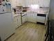 Kitchen with white cabinets, appliances, and light wood floors at 6305 N Ocean Blvd. # B-3, North Myrtle Beach, SC 29582