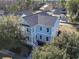 An aerial view of a light blue two-story home with a porch, surrounded by lush greenery at 1604 James Island Ave., North Myrtle Beach, SC 29582