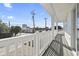 A cozy balcony with white railings and a view of the street and nearby buildings on a sunny day at 2401 Duffy St., North Myrtle Beach, SC 29582