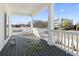 Spacious outdoor deck featuring a gray floor, white railings and pillars, and partial neighborhood views at 2401 Duffy St., North Myrtle Beach, SC 29582