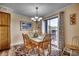 Bright dining area with wood table and chairs, chandelier lighting, and sliding glass door to the balcony at 5905 S Kings Hwy. # A 115, Myrtle Beach, SC 29575
