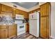 Functional kitchen with white appliances, wooden cabinets, mosaic backsplash, and tiled floors at 5905 S Kings Hwy. # A 115, Myrtle Beach, SC 29575