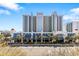 Beautiful condo building with underground parking, blue facade, and palm tree lined entrance at 2401 S Ocean Blvd. # 1156, Myrtle Beach, SC 29577