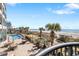 Elevated view of an outdoor pool with lounge chairs, tables, umbrellas, and lush landscaping overlooking the beach at 2401 S Ocean Blvd. # 1156, Myrtle Beach, SC 29577