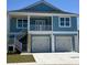 A two-story coastal home features a two-car garage and a charming second-story balcony at 2307 Tortuga Ln., North Myrtle Beach, SC 29582