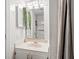 Bathroom featuring single sink vanity, framed mirror, decorative plant and tiled walls at 5905 S Kings Highway # 1117, Myrtle Beach, SC 29575