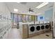 Well-lit laundry room featuring multiple washing machines, dryers, and large window offering natural light at 5905 S Kings Highway # 1117, Myrtle Beach, SC 29575