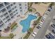 Overhead shot features a large pool surrounded by lounge chairs and palm trees at a condo complex at 5905 S Kings Highway # 1117, Myrtle Beach, SC 29575