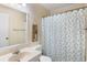 Well-lit bathroom with vanity sink, full mirror, and pineapple shower curtain at 6000 N Ocean Blvd. # 131, North Myrtle Beach, SC 29582